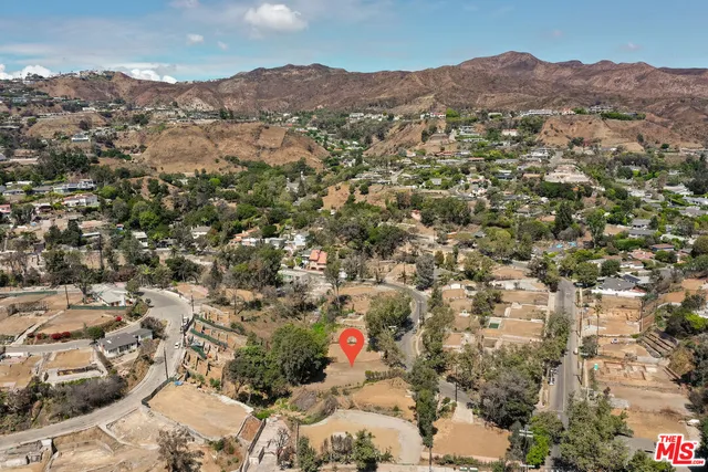 an aerial view of residential houses with outdoor space and trees