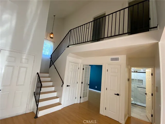 a view of a hallway with wooden floor and staircase