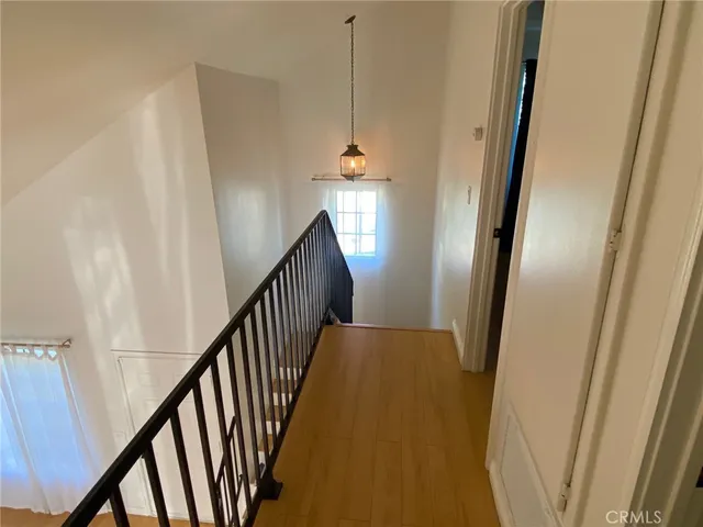 a view of a hallway with wooden floor and stairs
