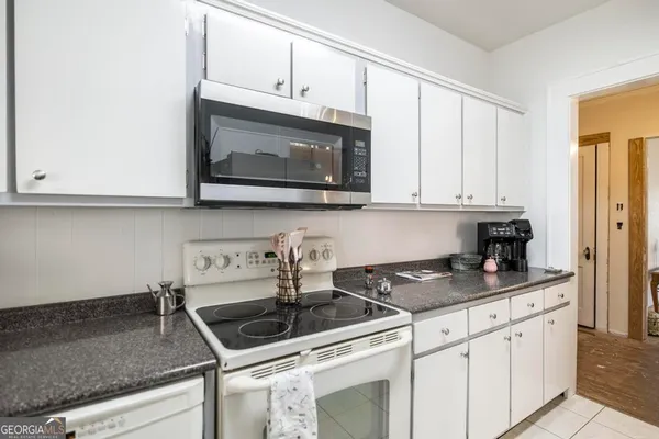 a kitchen with stainless steel appliances granite countertop white cabinets sink and stove