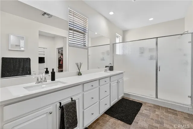 a spacious bathroom with double sink and a mirror