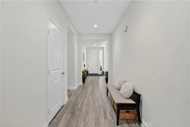 a view of a hallway with wooden floor and glass windows
