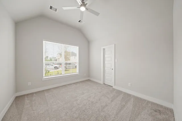 an empty room with a window and a ceiling fan