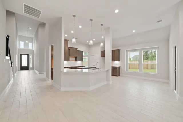 a view of a big room with wooden floor and windows