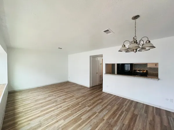 a view of a room with wooden floor and cabinets