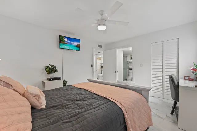 a bedroom with a bed and a potted plant