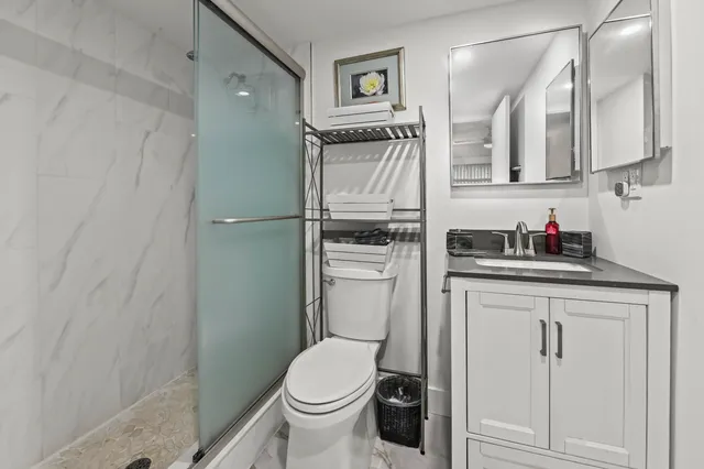 a bathroom with a granite countertop sink toilet and a mirror