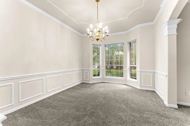 an empty room with windows and fireplace