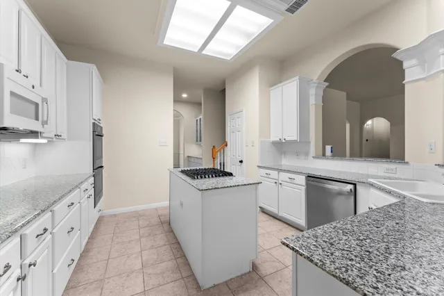 a kitchen with stainless steel appliances granite countertop a stove and a sink