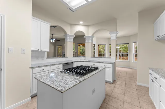 a kitchen with granite countertop white cabinets and white appliances