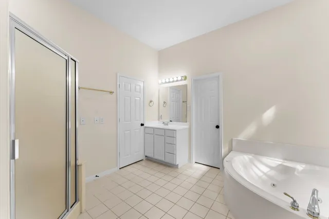 a spacious bathroom with a bathtub a sink and a mirror