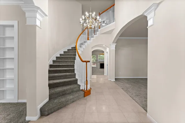 a view of hall way with furniture and a chandelier