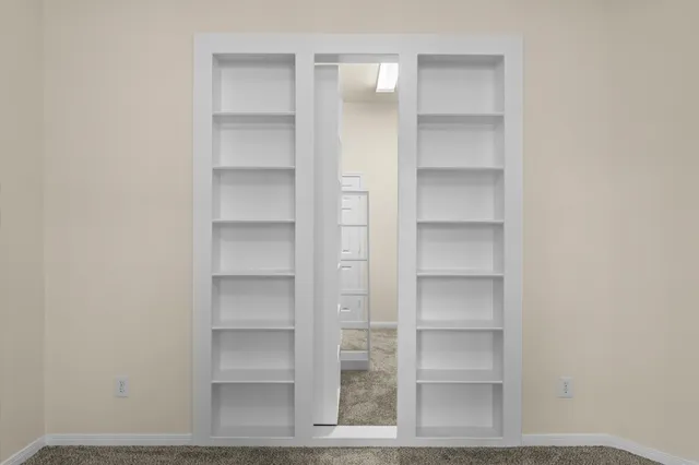 an empty room with windows and closet