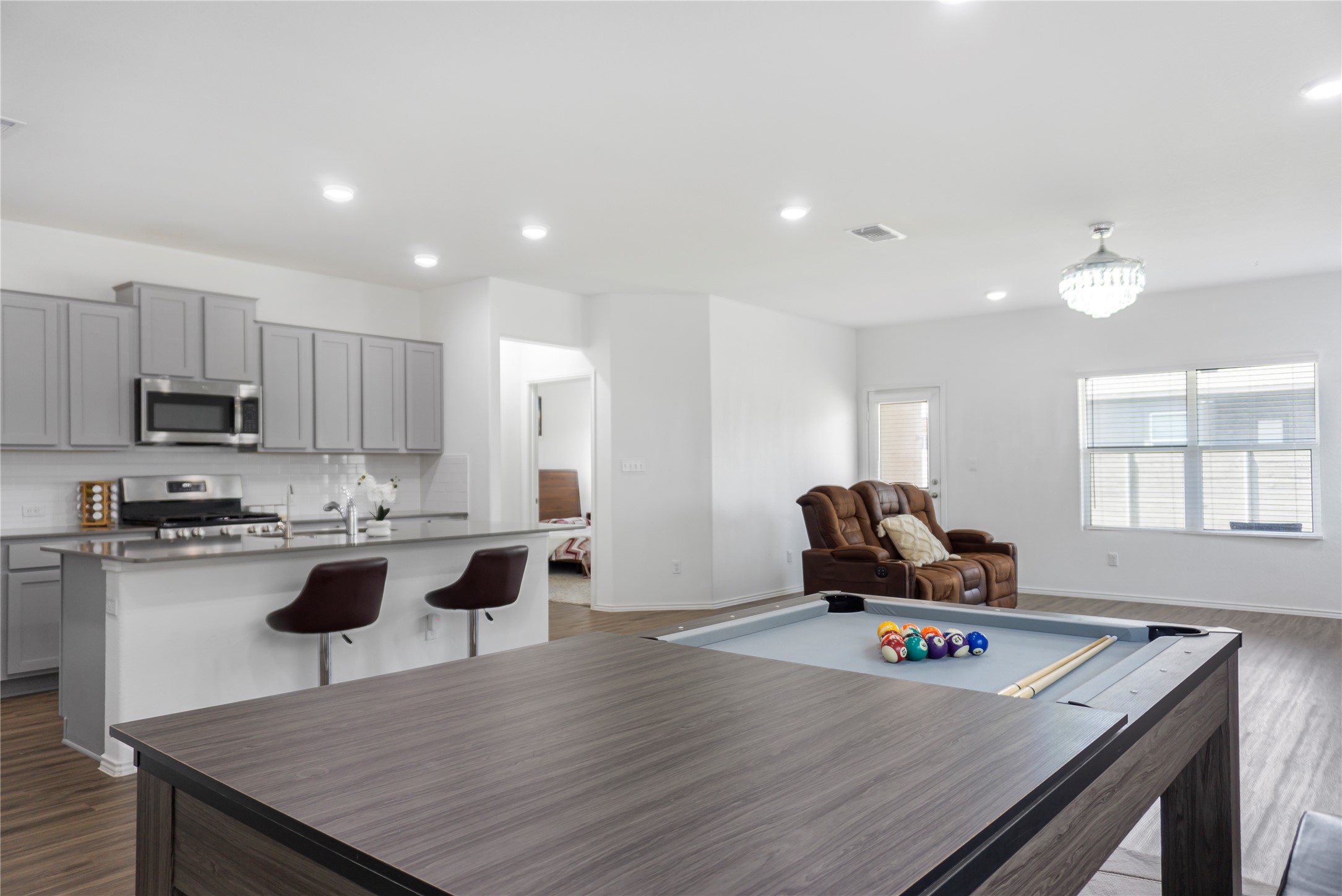 124 Cherry Ridge Road Georgetown, TX 78628 - Photo 11 of 23 Open-concept common area featuring wood-finish flooring, recessed lighting, and a modern kitchen