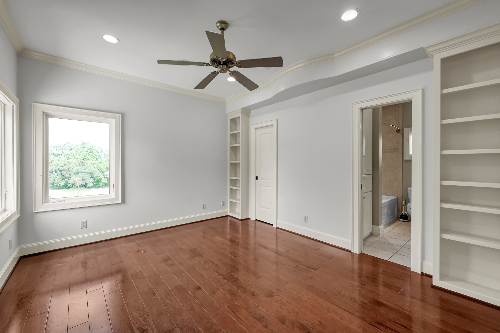 9602 Chatfield Street Houston, TX 77025 - Photo 35 of 48 an empty room with wooden floor a ceiling fan and windows