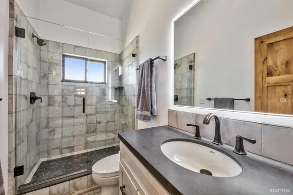 a bathroom with a sink toilet a mirror and shower