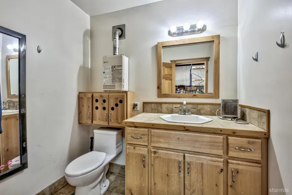 a bathroom with a granite countertop toilet sink and mirror