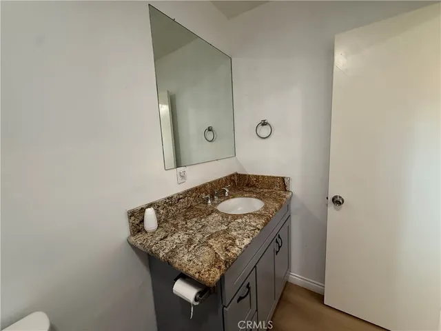 a bathroom with a granite countertop sink and a mirror