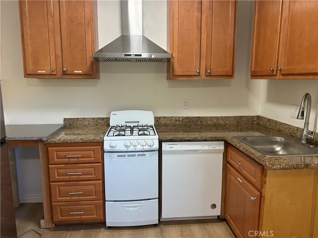 a kitchen with granite countertop cabinets stove and sink