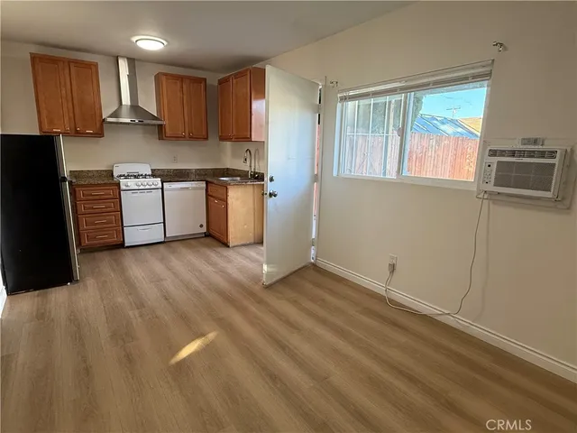 a kitchen with granite countertop a stove a sink and a refrigerator