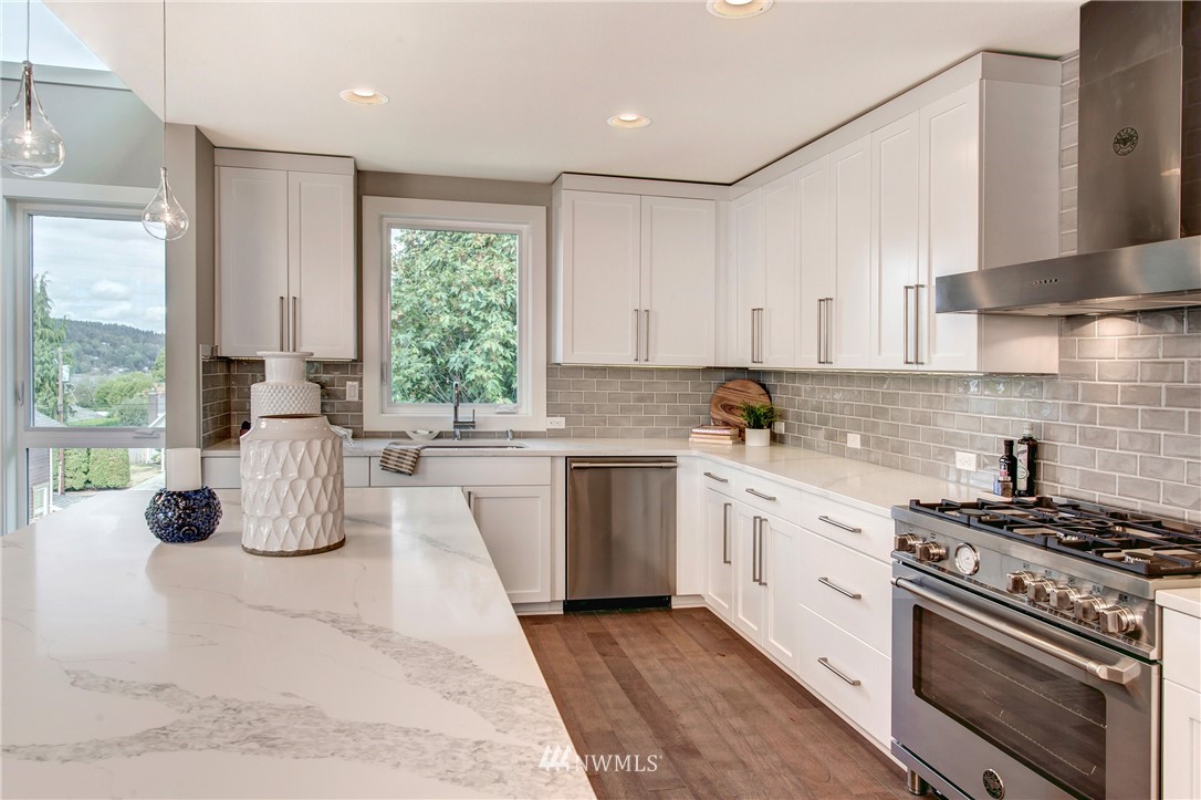 1002 North 30th Street Renton, WA 98056 - Photo 9 of 25 a kitchen with kitchen island granite countertop a sink cabinets and stainless steel appliances