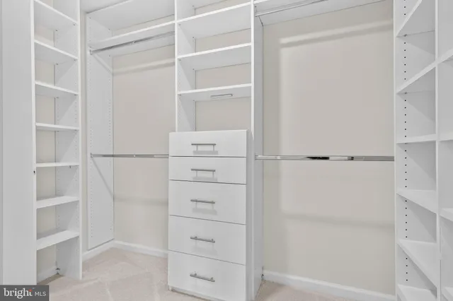 a kitchen with white cabinets and window