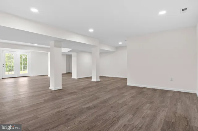 a view of an empty room with wooden floor