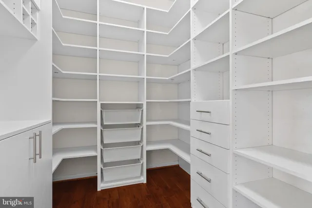 a view of walk in closet with empty racks