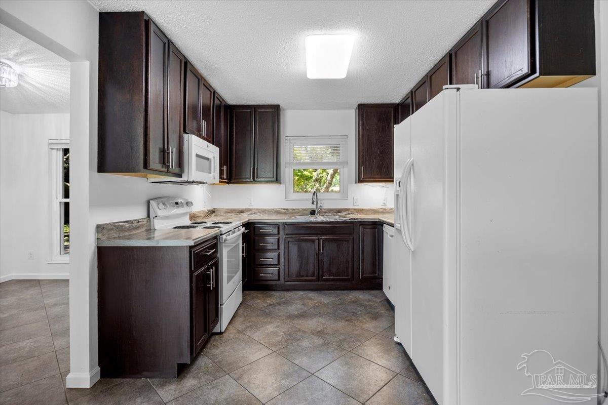 115 Bear Drive Gulf Breeze, FL 32561 - Photo 14 of 40 a large kitchen with stainless steel appliances a sink and a refrigerator