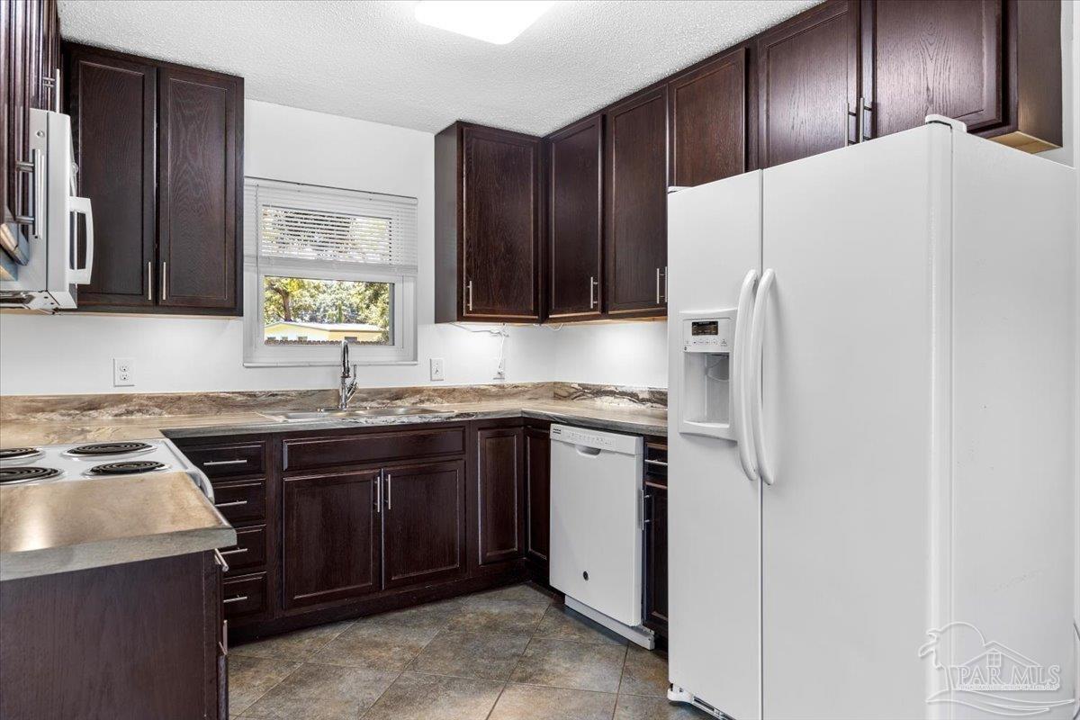 115 Bear Drive Gulf Breeze, FL 32561 - Photo 15 of 40 a kitchen with a sink and a refrigerator