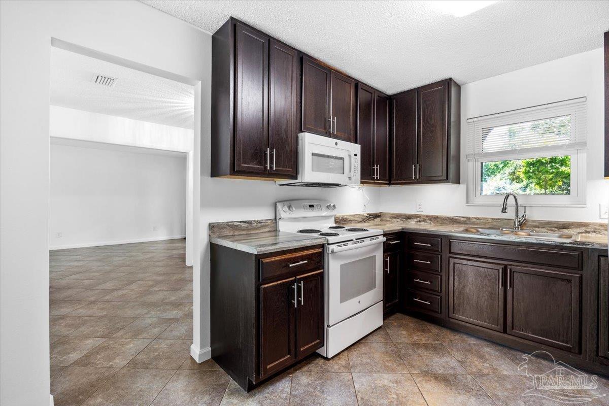 115 Bear Drive Gulf Breeze, FL 32561 - Photo 16 of 40 a kitchen with stainless steel appliances granite countertop a stove and a sink