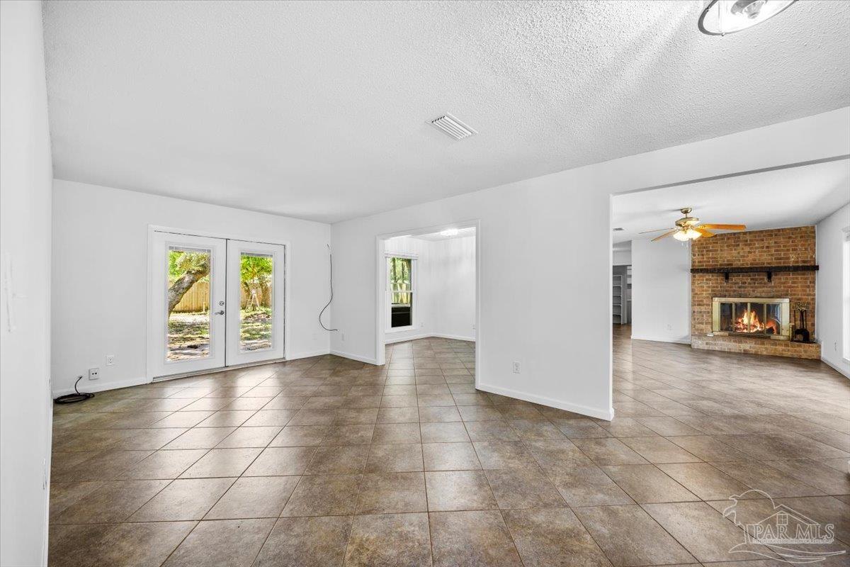 115 Bear Drive Gulf Breeze, FL 32561 - Photo 4 of 40 a view of an empty room with a fireplace and a window