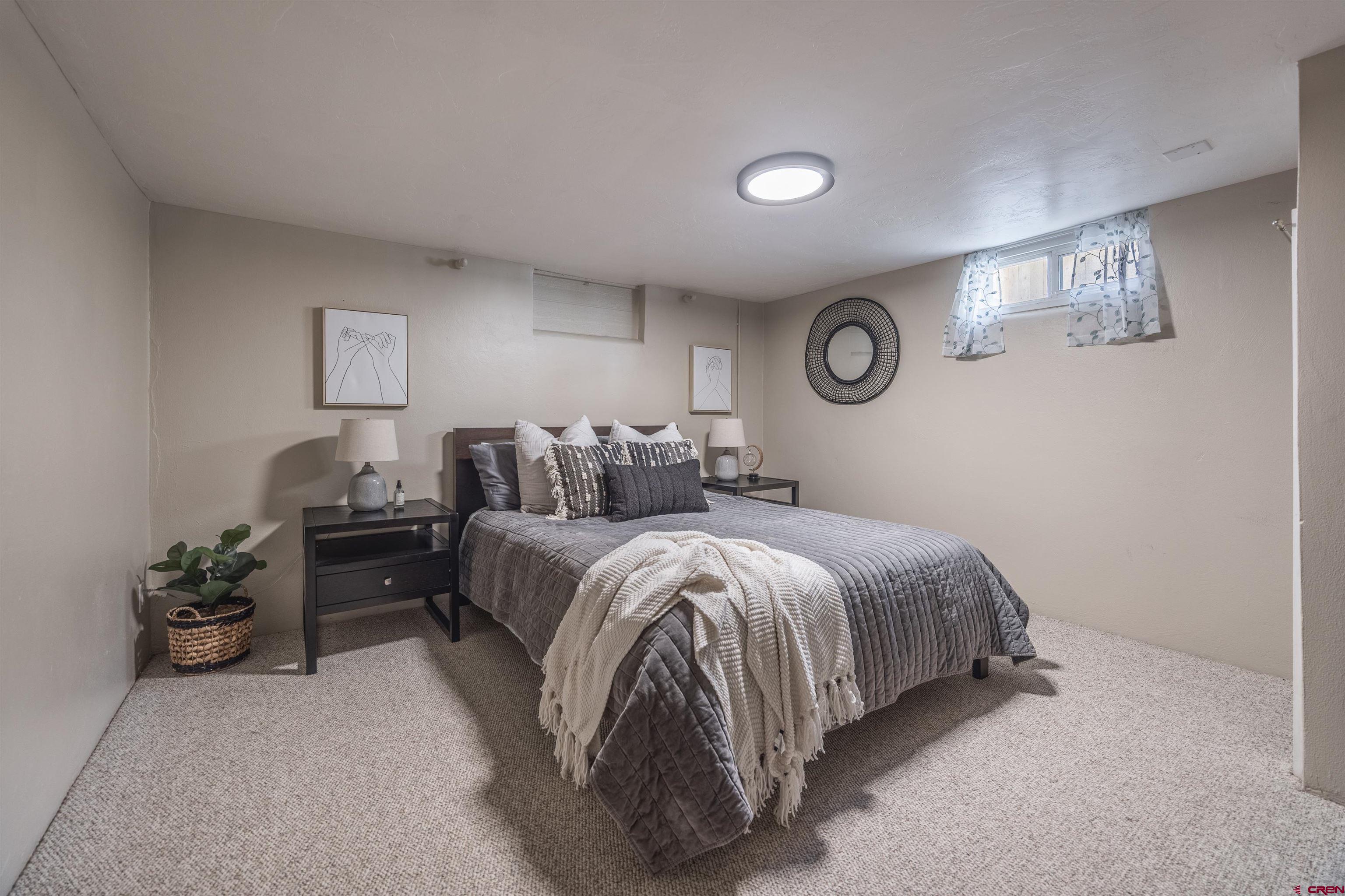 1146 South 2nd Street Montrose, CO 81401 - Photo 26 of 41 a spacious bedroom with a bed and a lamp