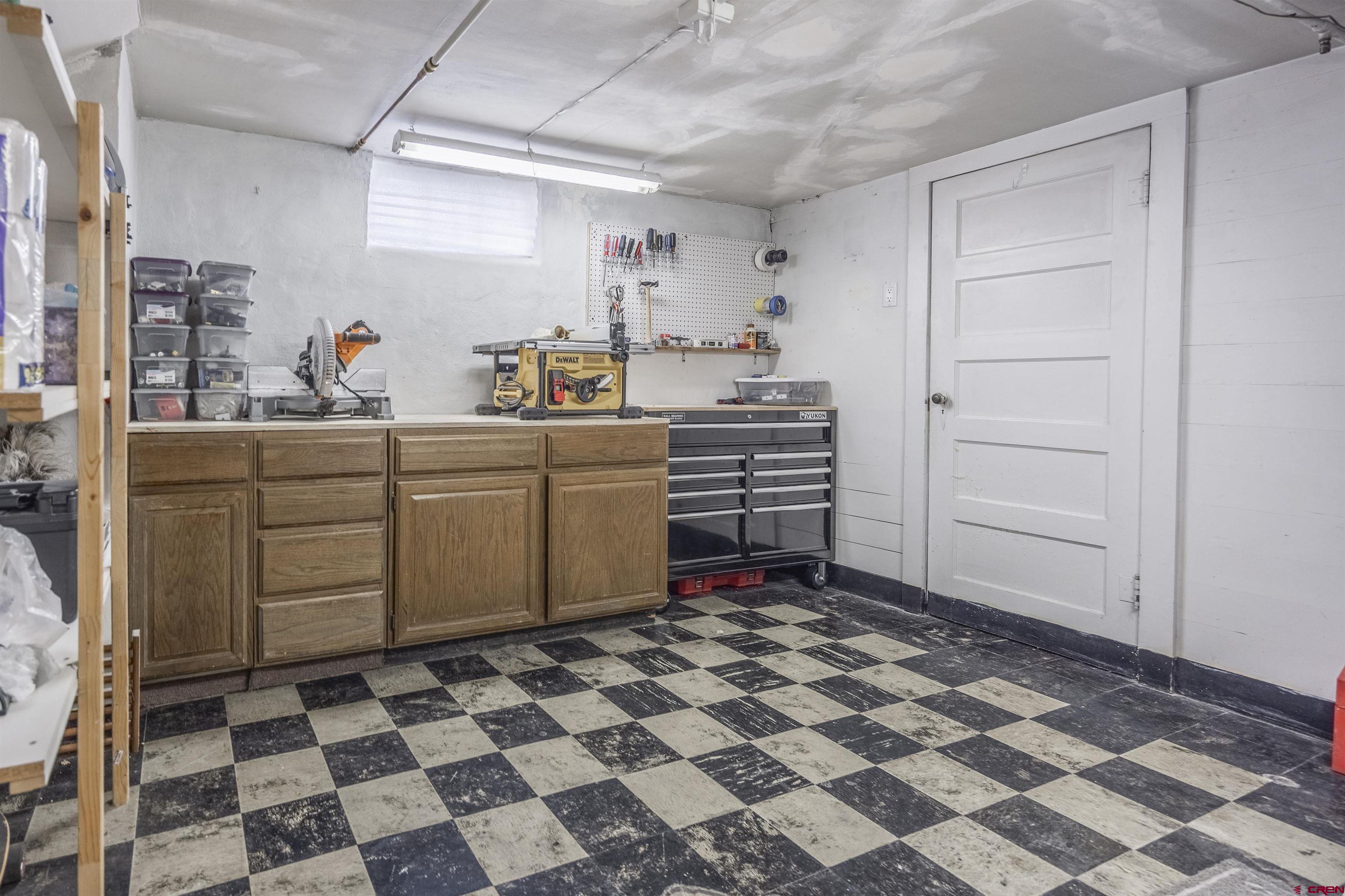 1146 South 2nd Street Montrose, CO 81401 - Photo 31 of 41 a kitchen with a checkered floor and white cabinets