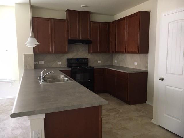 7700 Crystalbrook West Austin, TX 78724 - Photo 4 of 11 a kitchen with granite countertop a sink a stove and cabinets