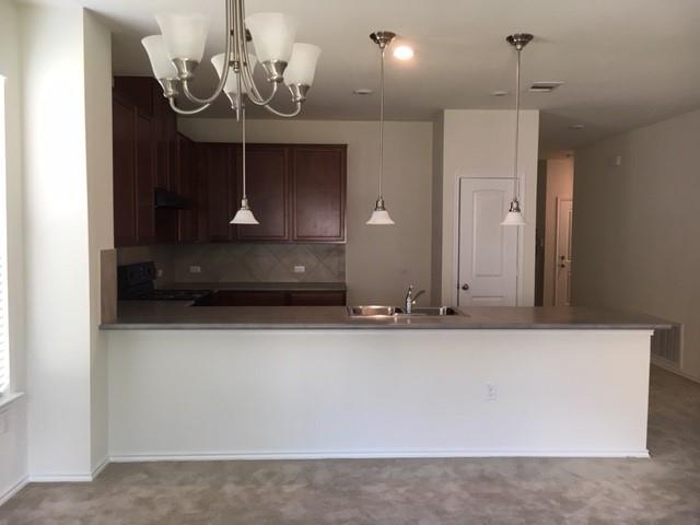 7700 Crystalbrook West Austin, TX 78724 - Photo 6 of 11 a view of a hallway with a chandelier