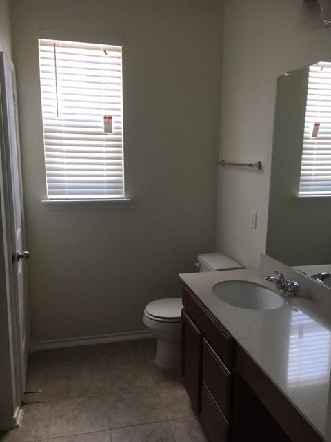7700 Crystalbrook West Austin, TX 78724 - Photo 8 of 11 a bathroom with a granite countertop toilet a sink and a window