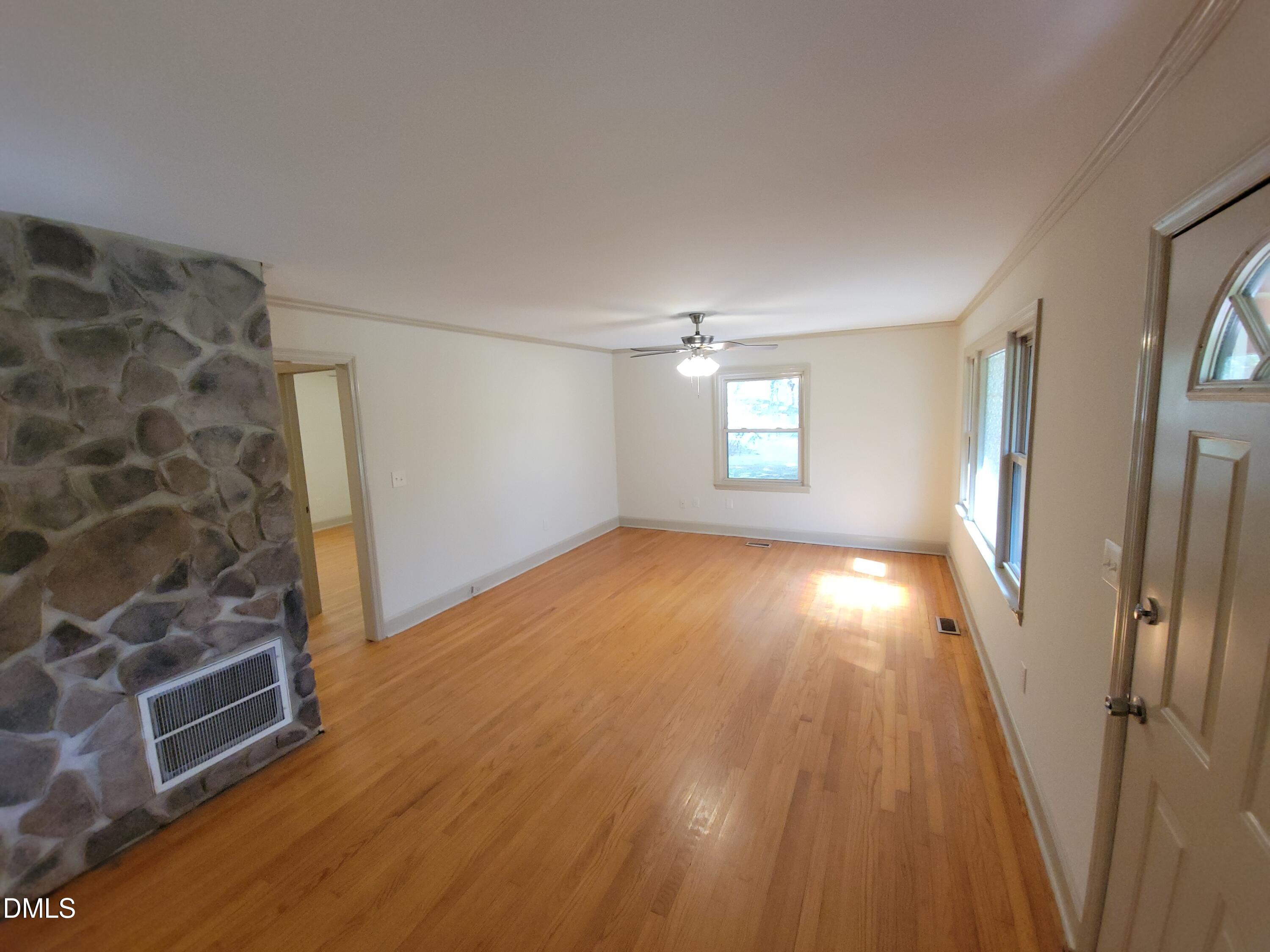 7000 Holly Springs Road Raleigh, NC 27606 - Photo 5 of 24 wooden floor in an empty room with a window