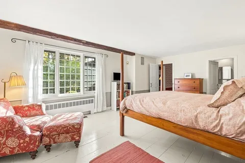 a spacious bedroom with a bed and lamp