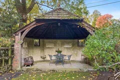 a view of backyard with table and chairs under an umbrella