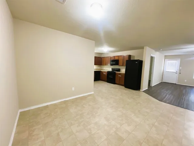 a view of kitchen with refrigerator and wooden floor