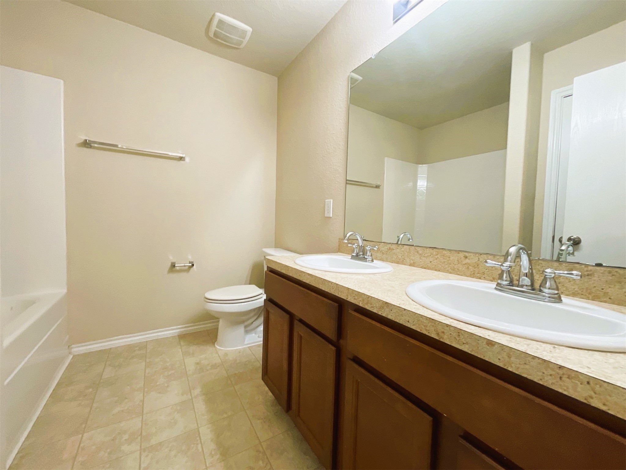 819 Katydid Court Conroe, TX 77301 - Photo 20 of 26 a bathroom with a double vanity sink toilet and a mirror