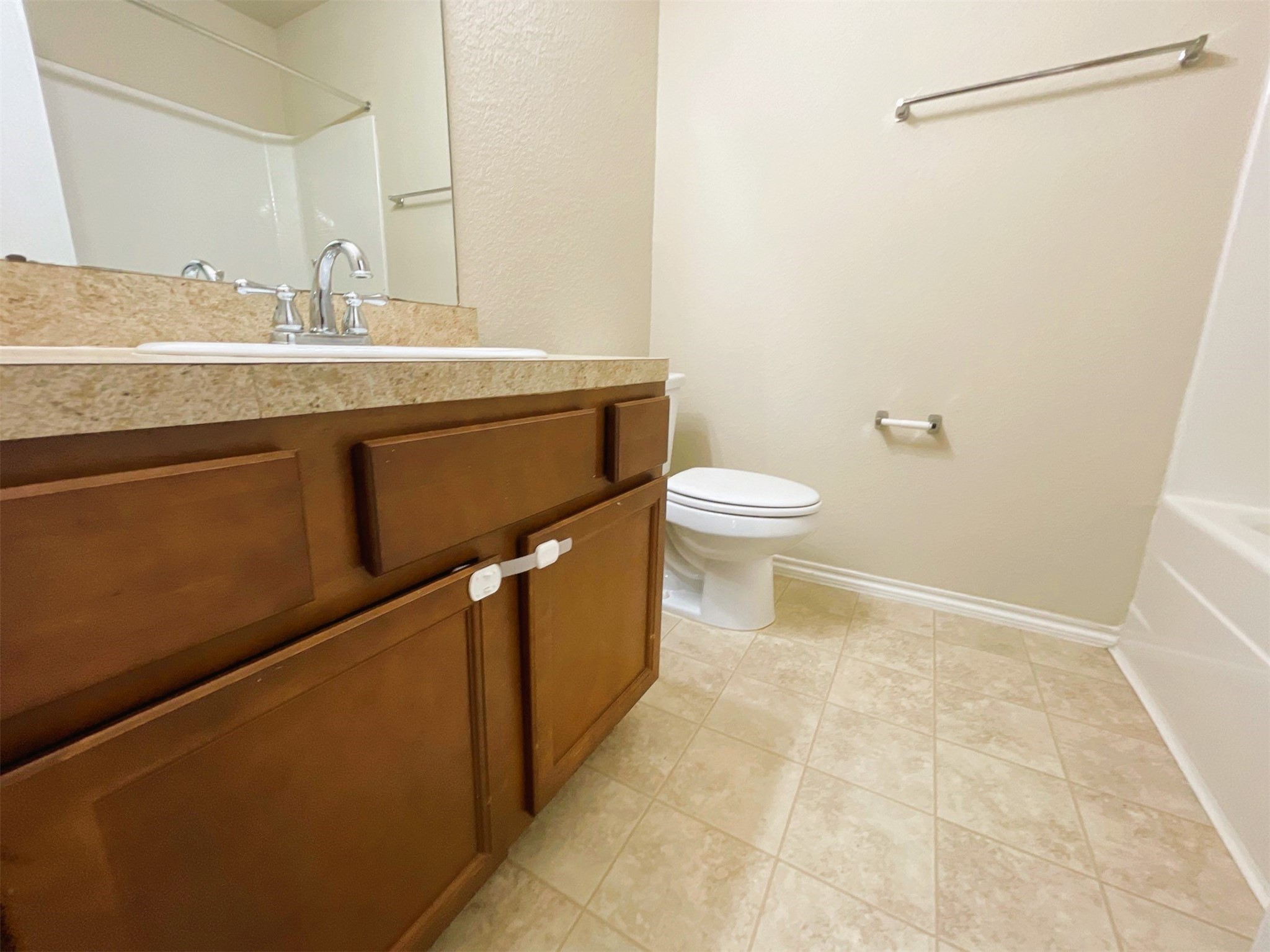 819 Katydid Court Conroe, TX 77301 - Photo 21 of 26 a bathroom with a granite countertop sink a toilet and a mirror