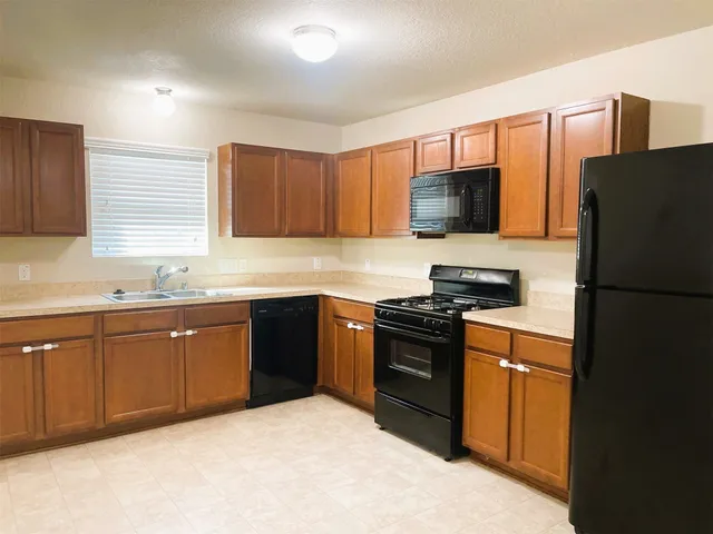 a kitchen with a refrigerator stove top oven and sink