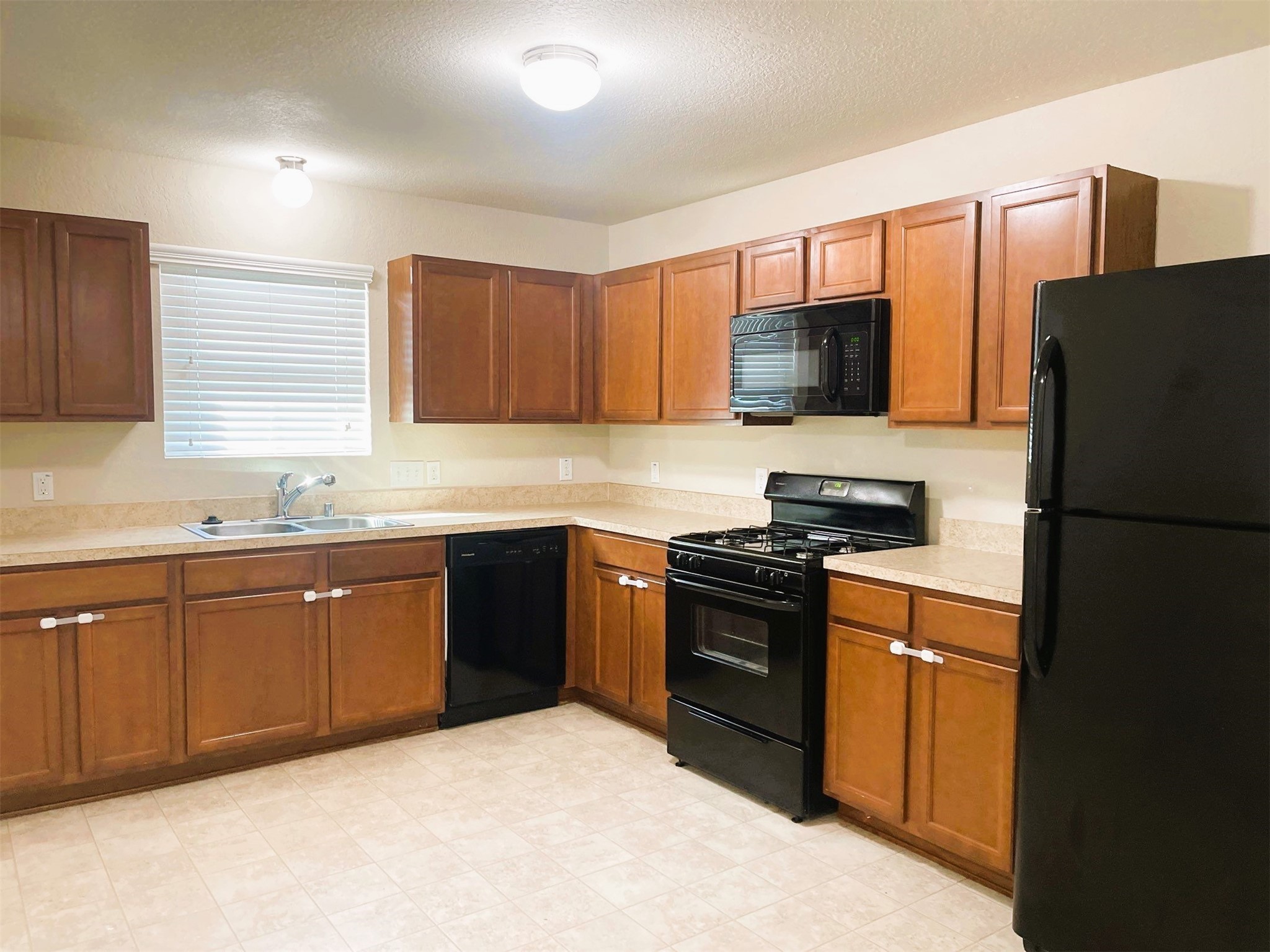 819 Katydid Court Conroe, TX 77301 - Photo 5 of 26 a kitchen with a refrigerator stove top oven and sink