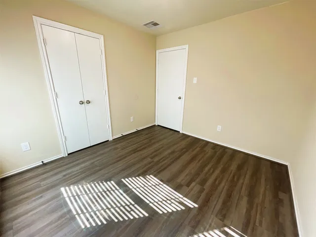 a view of a room with wooden floor