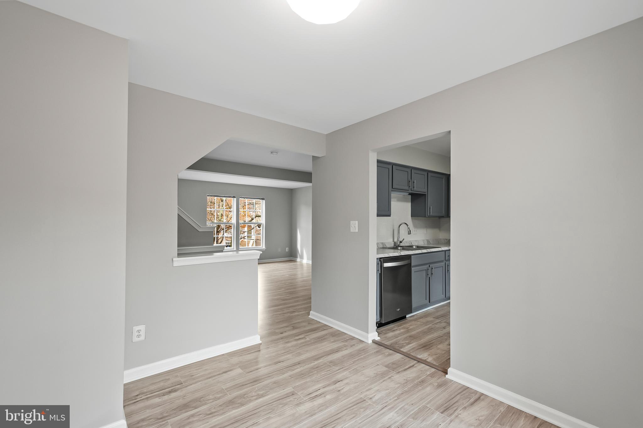 10305 Butternut Circle Manassas, VA 20110 - Photo 23 of 30 an empty room with wooden floor kitchen view and windows