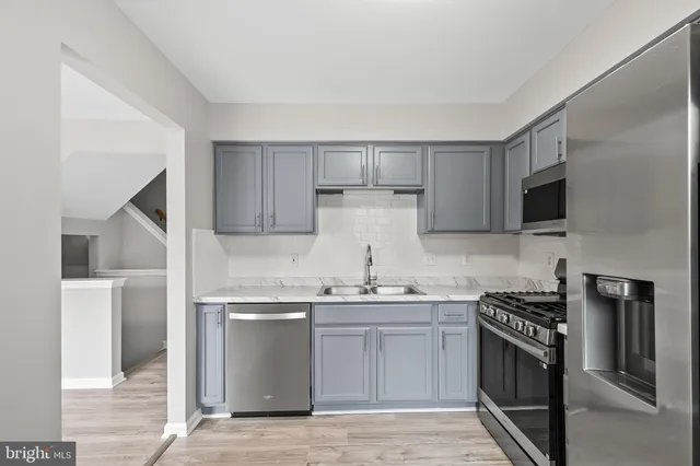 a kitchen with stainless steel appliances a sink stove and refrigerator
