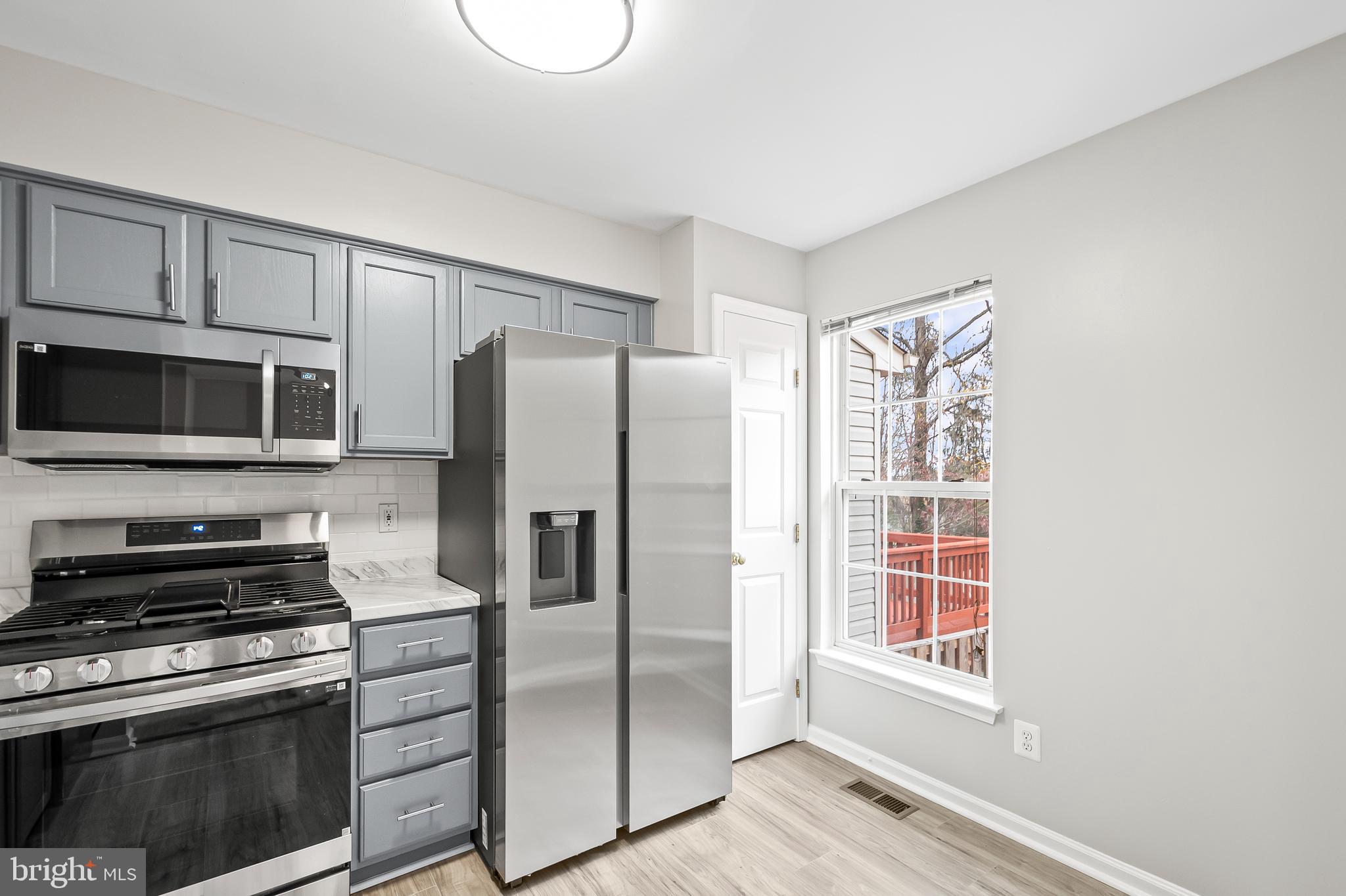 10305 Butternut Circle Manassas, VA 20110 - Photo 9 of 30 a kitchen with stainless steel appliances a refrigerator stove and microwave