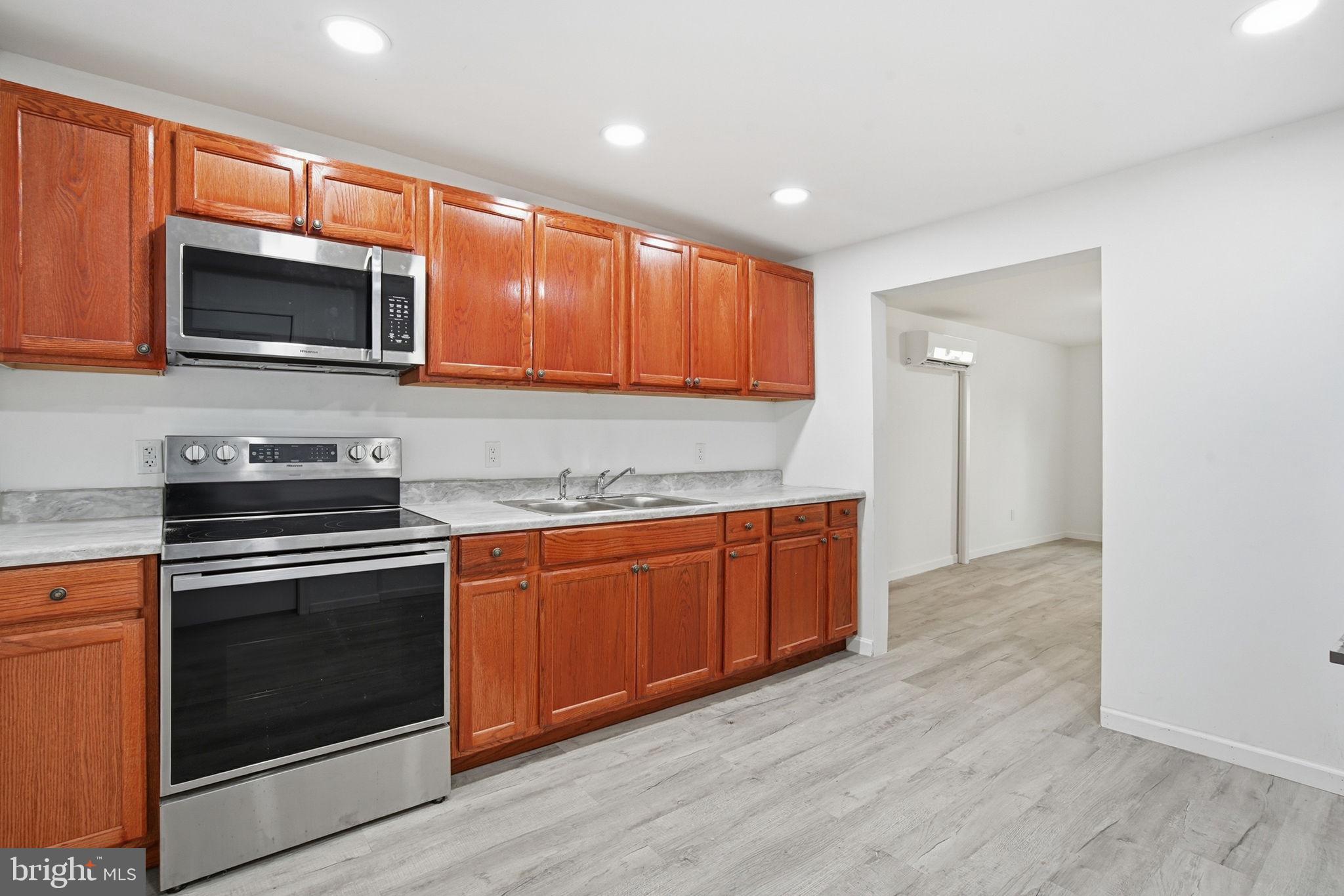 603 Academy Street Cambridge, MD 21613 - Photo 5 of 22 a kitchen with stainless steel appliances granite countertop a stove microwave and sink